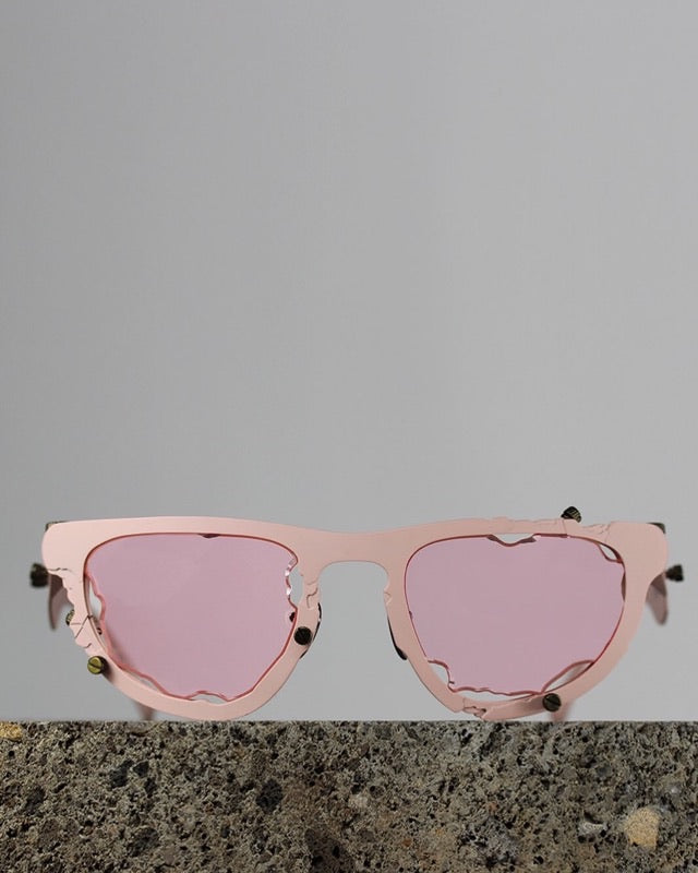 Titanium Museum sunglasses in pink with pink lenses on a stone block