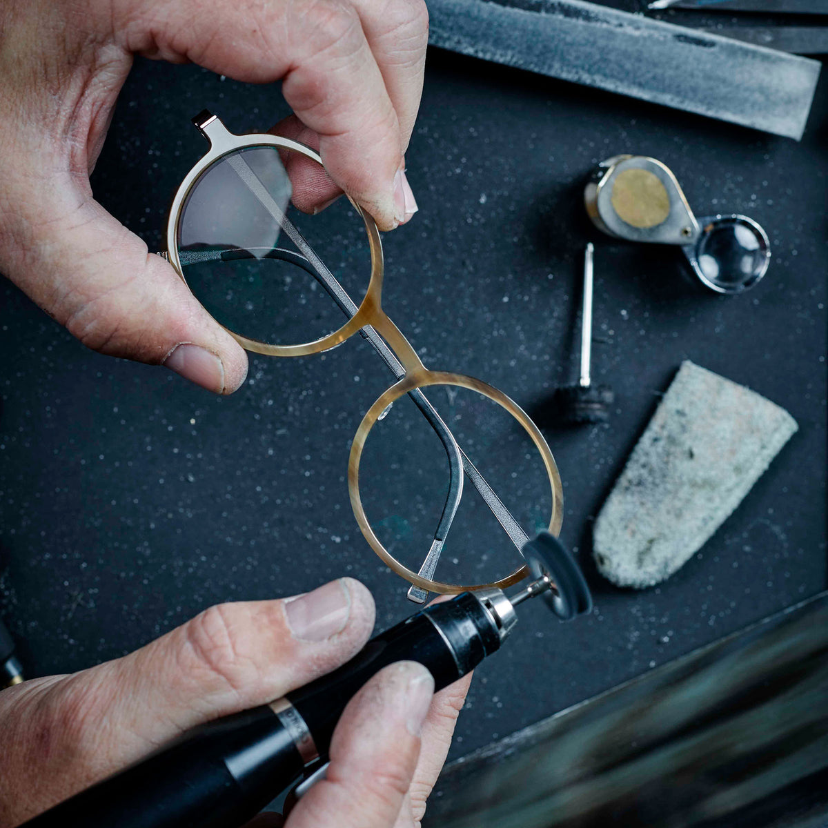 Hands finishing a LINDBERG buffalo horn frame at a workbench